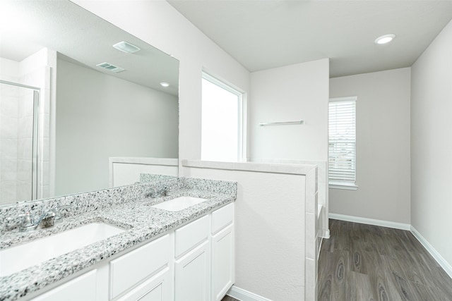 bathroom featuring hardwood / wood-style flooring, vanity, a healthy amount of sunlight, and a shower with shower door