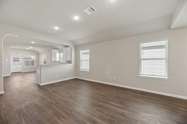 unfurnished living room featuring vaulted ceiling and dark hardwood / wood-style floors