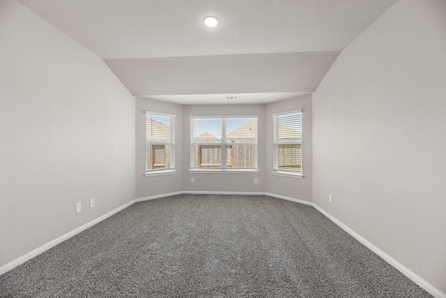 carpeted spare room with lofted ceiling