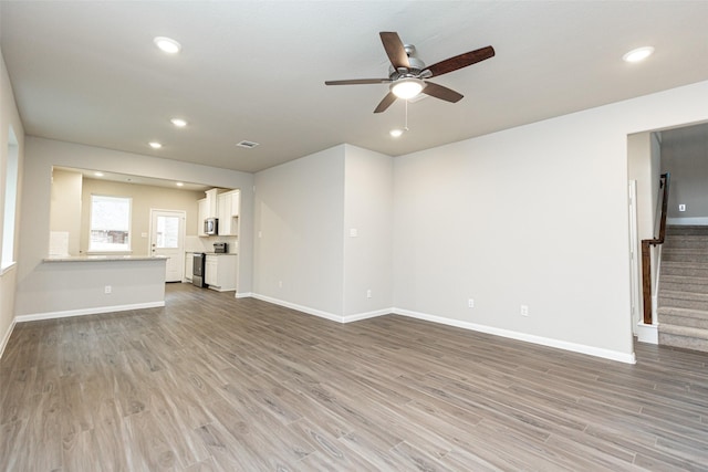 unfurnished living room featuring hardwood / wood-style floors and ceiling fan