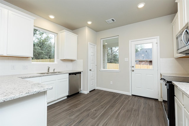 kitchen featuring white cabinetry, sink, light stone counters, and appliances with stainless steel finishes