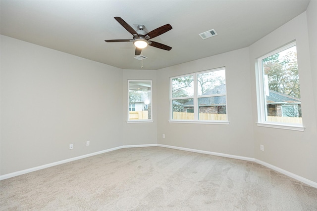 empty room with ceiling fan and light carpet