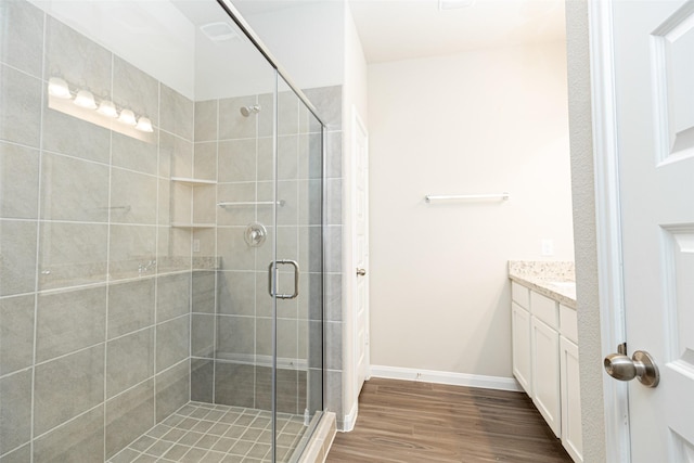 bathroom featuring a shower with door, vanity, and wood-type flooring