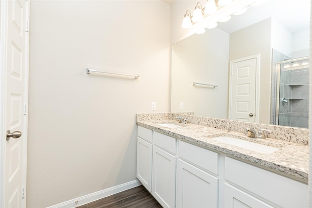 bathroom featuring wood-type flooring, a shower with shower door, and vanity