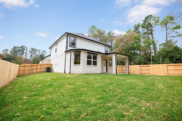 back of house featuring cooling unit and a lawn