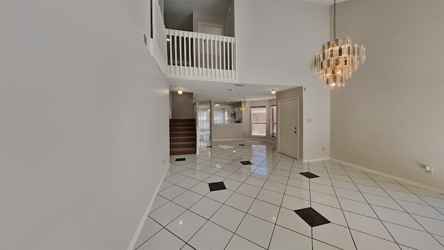 tiled foyer entrance featuring a notable chandelier and a towering ceiling