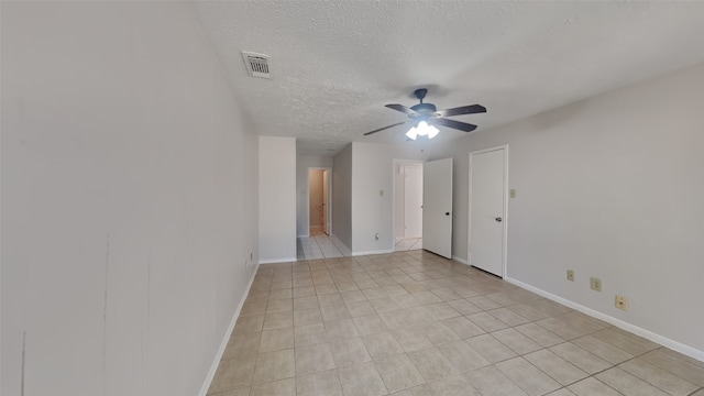 tiled empty room with a textured ceiling and ceiling fan