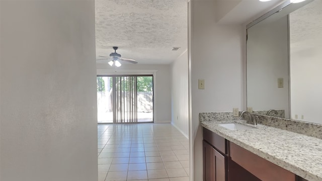 bathroom featuring vanity, ceiling fan, tile patterned floors, and a textured ceiling