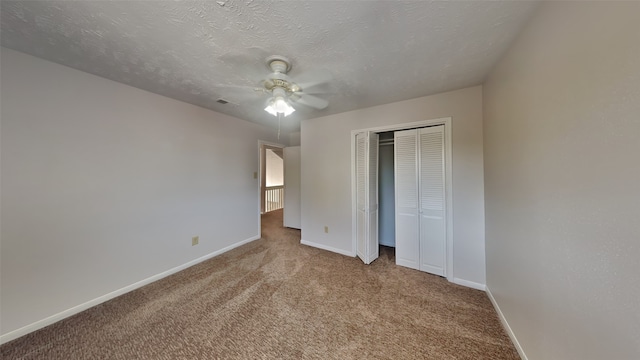 unfurnished bedroom featuring a textured ceiling, a closet, ceiling fan, and carpet flooring