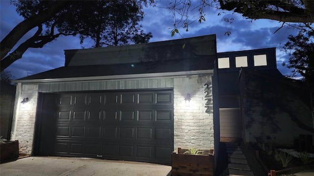 view of garage at dusk