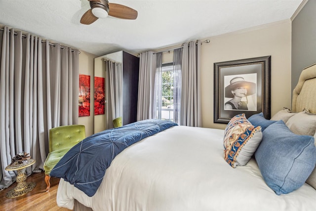 bedroom with hardwood / wood-style flooring, ceiling fan, and ornamental molding