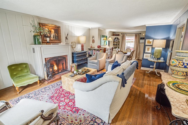 living room featuring crown molding, dark hardwood / wood-style flooring, a brick fireplace, and a textured ceiling