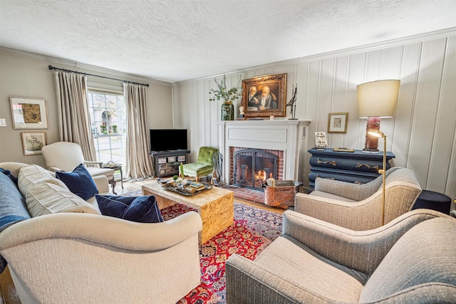 living room with hardwood / wood-style flooring, a fireplace, ornamental molding, and a textured ceiling