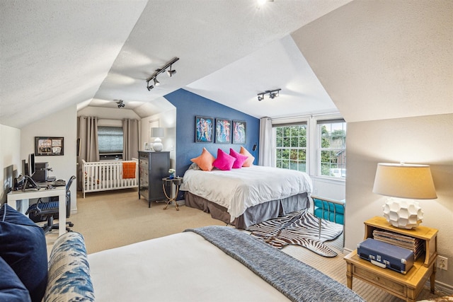 bedroom with lofted ceiling, a textured ceiling, and carpet flooring