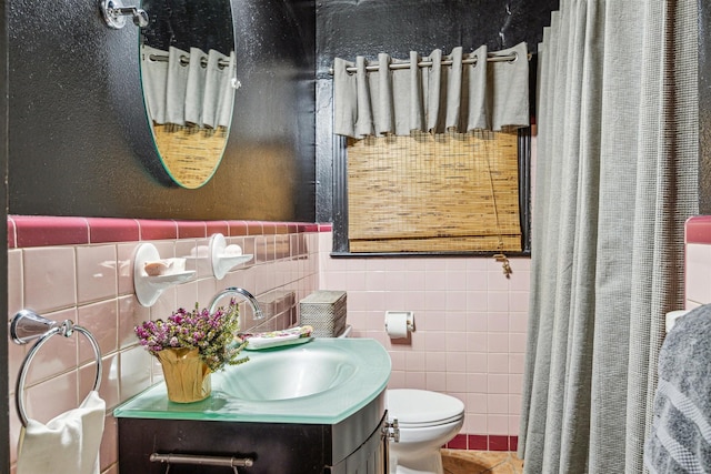 bathroom with vanity, toilet, and tile walls