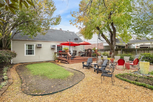 view of yard with a deck, a wall unit AC, and an outdoor fire pit