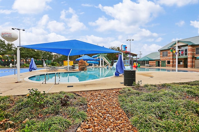 view of swimming pool with a patio area and a water slide