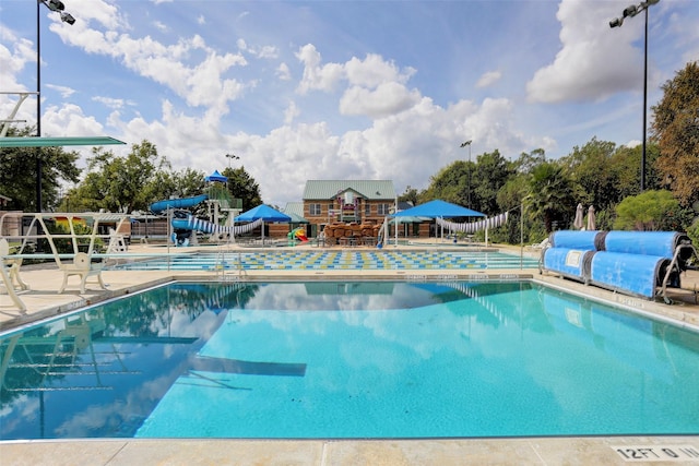 view of pool with a water slide and a patio