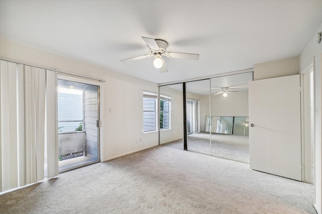 unfurnished bedroom with multiple windows, light carpet, a closet, and ceiling fan