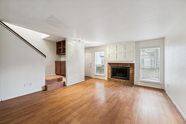 unfurnished living room with a fireplace and light wood-type flooring