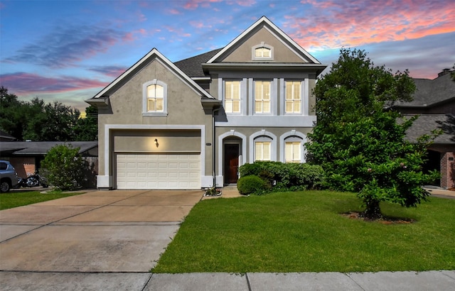 view of front of home with a garage and a yard