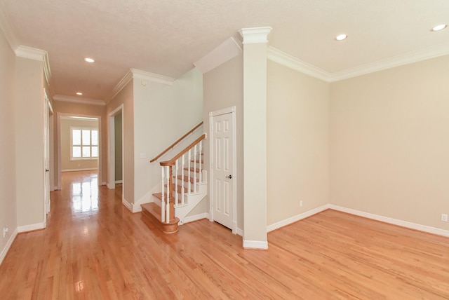 interior space with decorative columns, ornamental molding, and light hardwood / wood-style floors