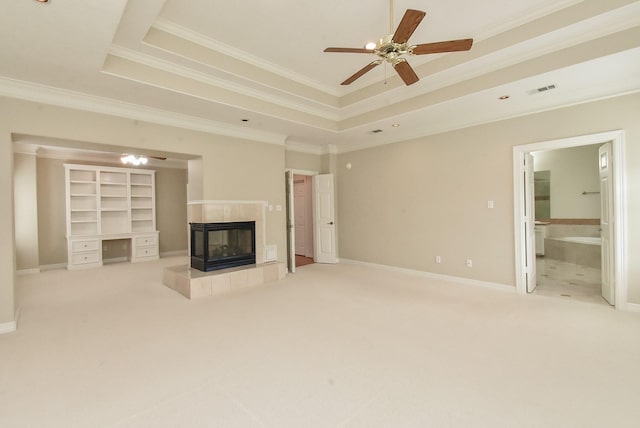 unfurnished living room with a tiled fireplace, ornamental molding, and light colored carpet