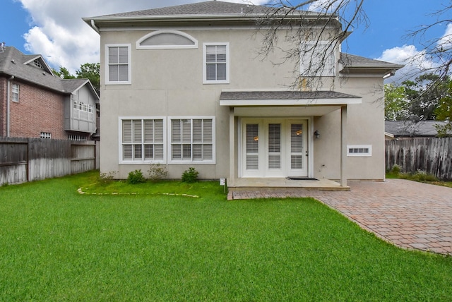 back of property with a lawn and a patio area