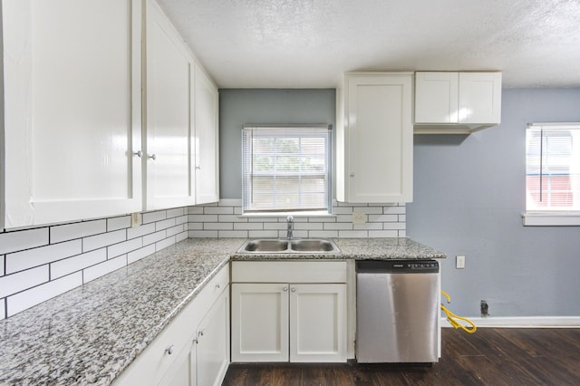 kitchen with tasteful backsplash, dishwasher, a healthy amount of sunlight, white cabinetry, and a sink