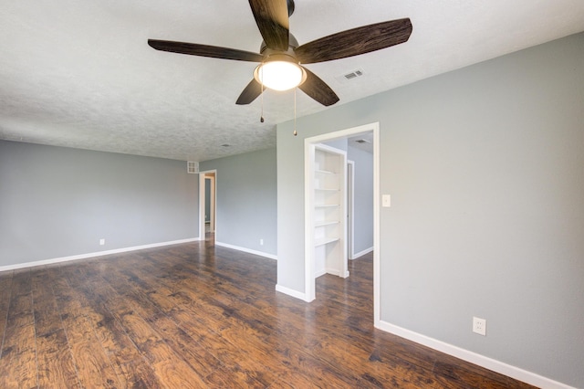 spare room with visible vents, a ceiling fan, a textured ceiling, wood finished floors, and baseboards