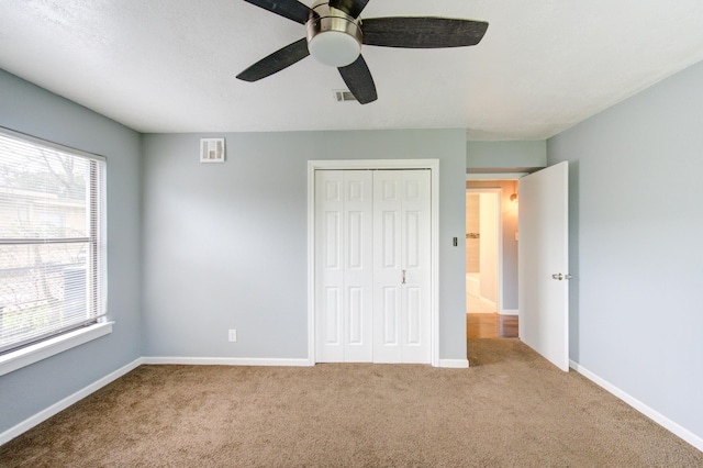 unfurnished bedroom with a closet, visible vents, baseboards, and carpet flooring