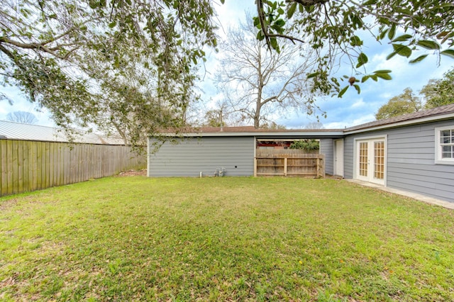 view of yard with a fenced backyard and french doors