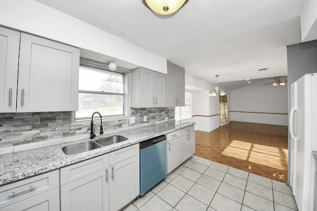 kitchen featuring sink, light tile patterned floors, white refrigerator, stainless steel dishwasher, and decorative backsplash