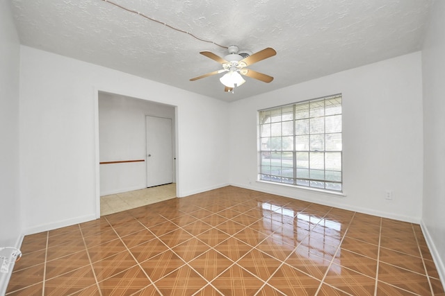 tiled spare room featuring a textured ceiling and ceiling fan