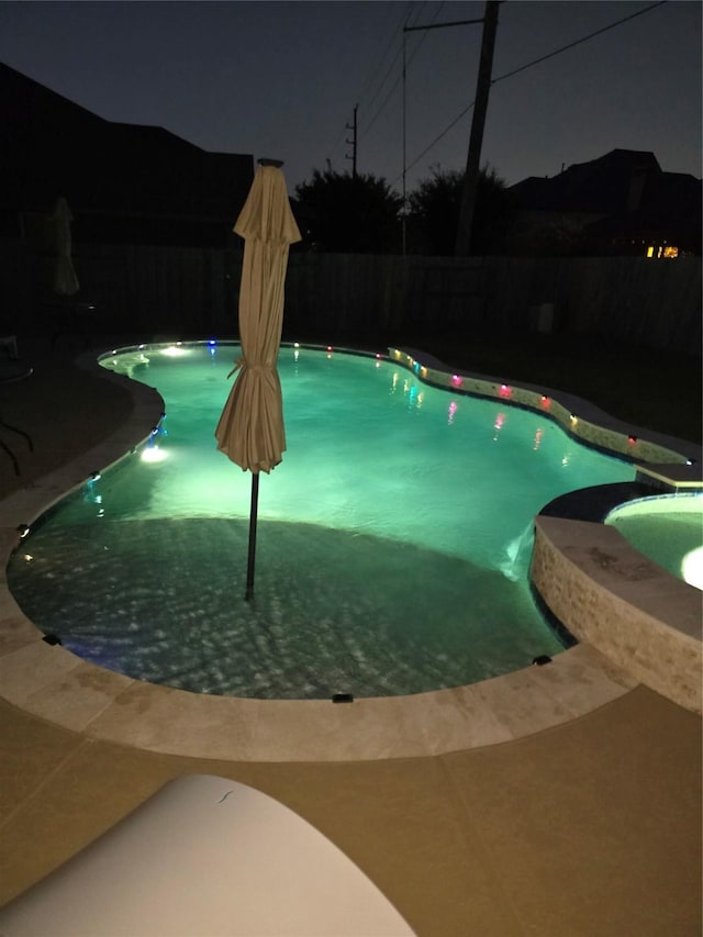 view of pool at twilight