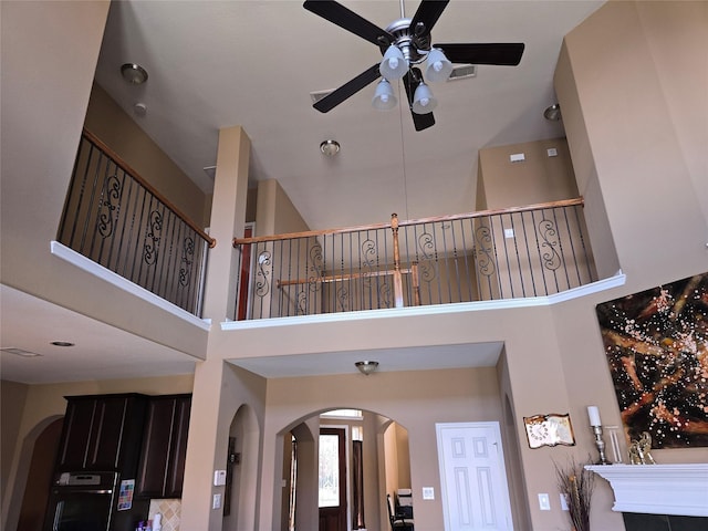 interior space with a high ceiling and ceiling fan