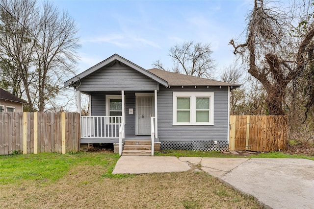 bungalow-style home featuring covered porch and a front lawn