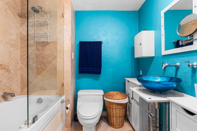 full bathroom featuring vanity, tile patterned flooring, toilet, and tiled shower / bath