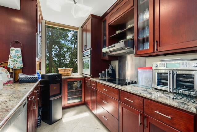 kitchen with light stone counters, appliances with stainless steel finishes, beverage cooler, and light tile patterned floors