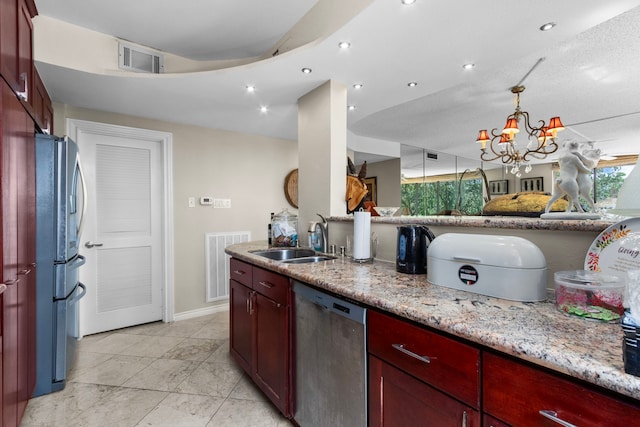 kitchen featuring sink, stainless steel appliances, a notable chandelier, light stone countertops, and a textured ceiling