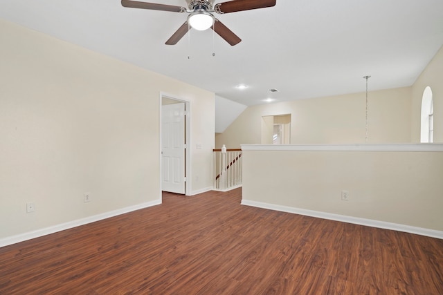 empty room featuring dark hardwood / wood-style flooring, vaulted ceiling, and ceiling fan