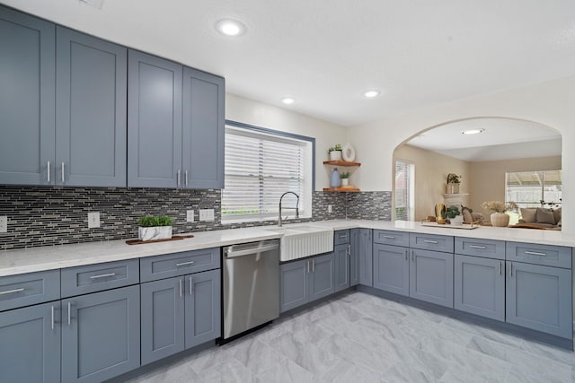 kitchen with plenty of natural light, sink, stainless steel dishwasher, and decorative backsplash