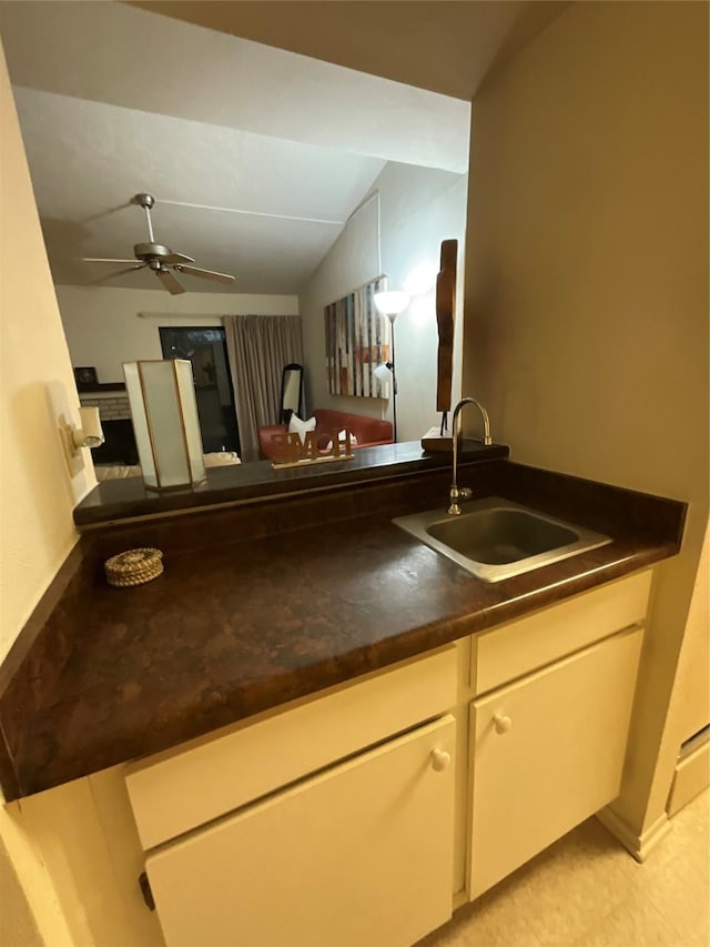 kitchen with lofted ceiling, sink, ceiling fan, and kitchen peninsula