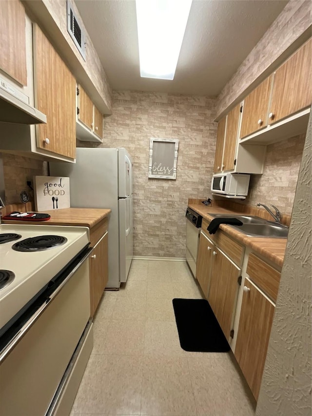 kitchen featuring white appliances, sink, and exhaust hood