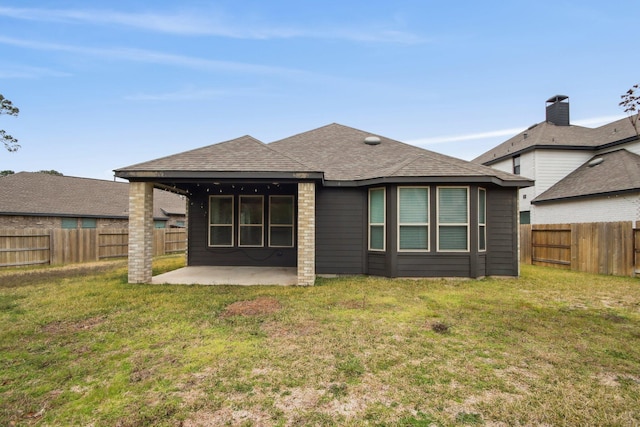 rear view of house featuring a lawn and a patio area