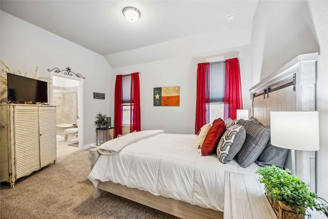 bedroom featuring lofted ceiling, connected bathroom, and carpet floors