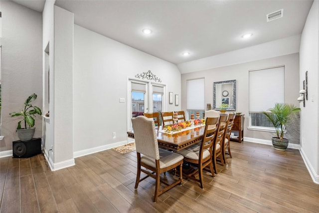 dining space featuring lofted ceiling and wood-type flooring