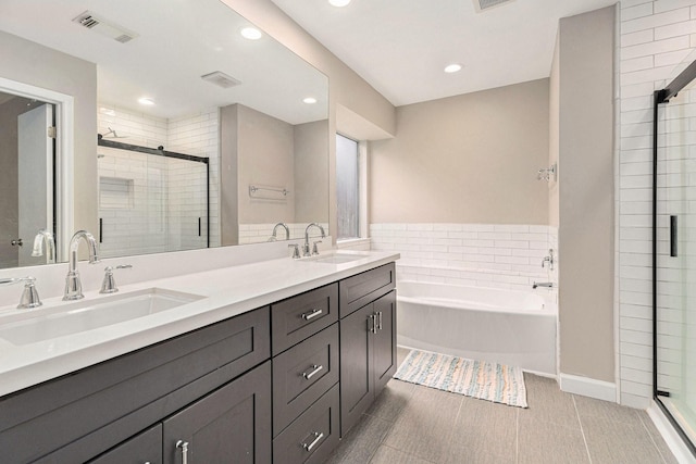 bathroom featuring tile patterned flooring, vanity, and shower with separate bathtub