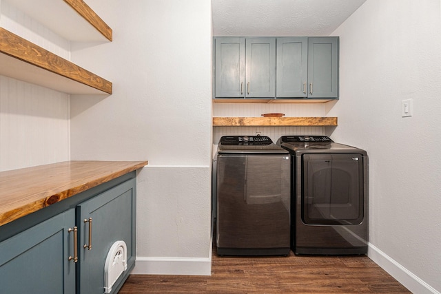 washroom with cabinets, dark wood-type flooring, and washing machine and clothes dryer