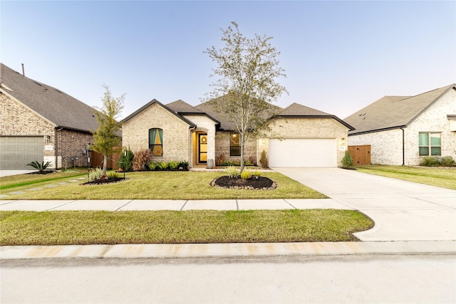 french country inspired facade featuring a garage and a front yard